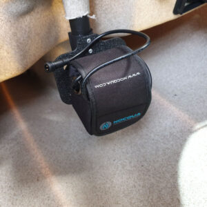 Nestled under a sleek beige surface, you've got your compact black battery pack all sorted. It's snugly secured in a Nocqua 25mm (1 Inch) Shaft Battery Mount, keeping everything tidy and efficient. Ready to power up without a fuss!.