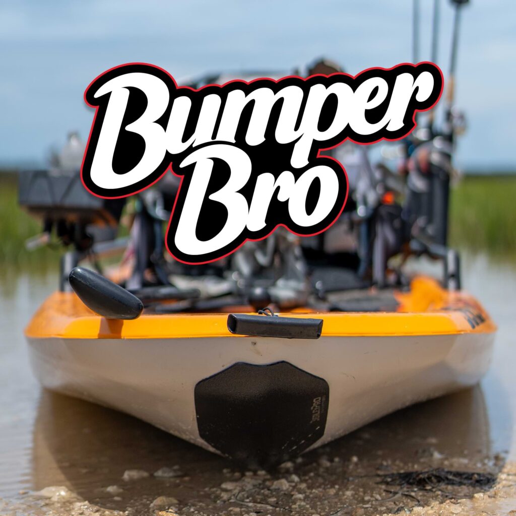 A fishing kayak is chilling on the rocky shoreline, its bow proudly flaunting the "Bumper Bro" logo from the Bumper Bro Kayak Keel Guard.