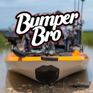 A fishing kayak is chilling on the rocky shoreline, its bow proudly flaunting the "Bumper Bro" logo from the Bumper Bro Kayak Keel Guard.