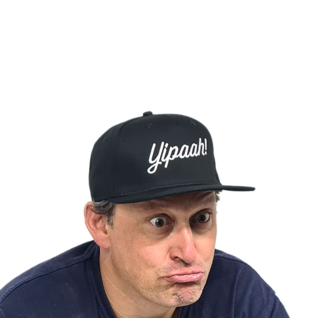 Rocking a Yipaah Cap, this person strikes a playful pose with lips curved into a cheeky grin, ready to take on whatever the day throws their way.