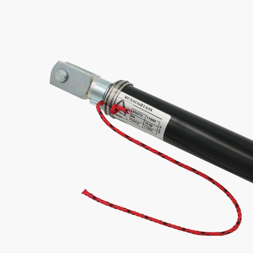 Say hello to the Will-I-Loader Gas Assist Strut, where functionality meets flair! This sleek, black hydraulic cylinder is designed with precision and features sturdy metal attachments that highlight its high-quality craftsmanship. The standout feature? A vibrant red rope casually tied around one end, adding a touch of character and contrast to its rugged look. Perfectly engineered for performance while catching the eye with its unique style!.